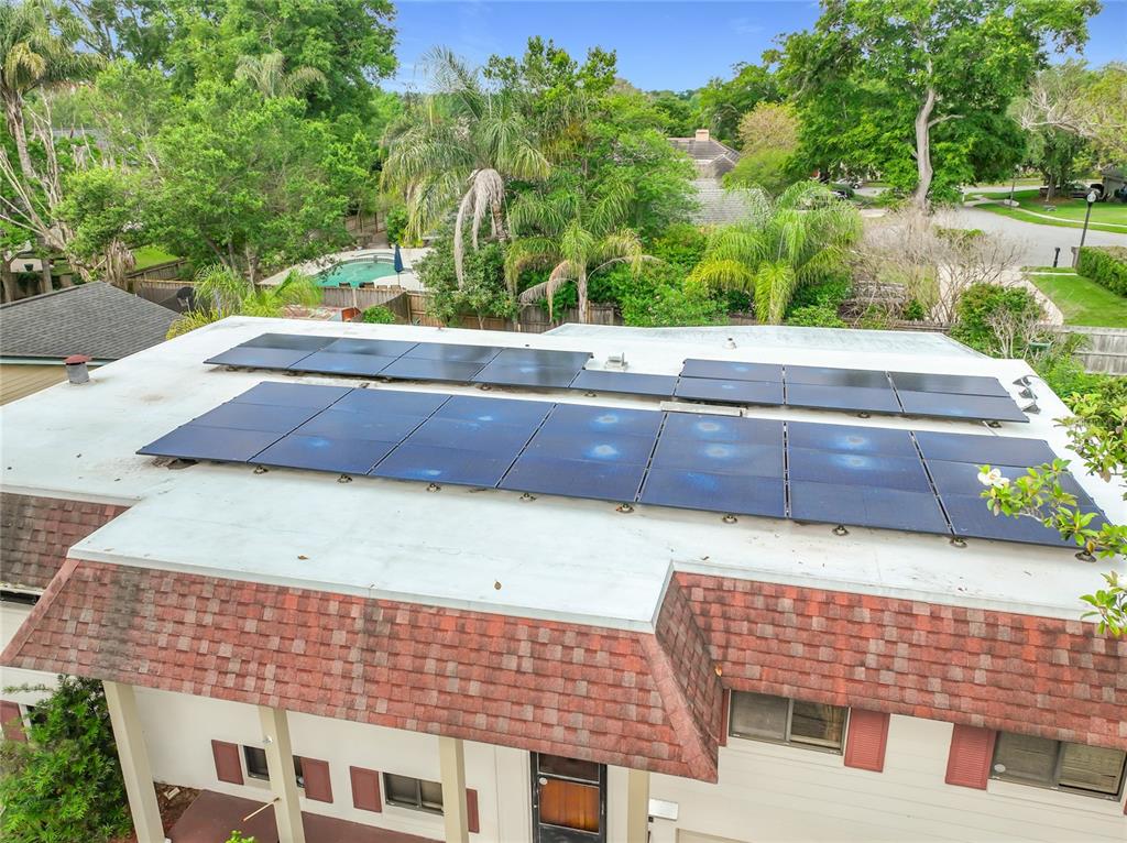 An elevated view of a flat roof featuring a large array of solar panels — 1511 GLASTONBERRY ROAD, MAITLAND, FL