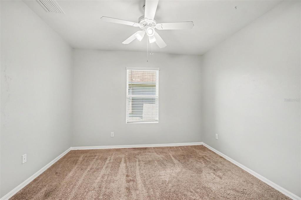 A kitchen features dark wood cabinets, a black stove, a microwave, and a tiled backsplash — 7048 WATERFORD PARKWAY, PUNTA GORDA, FL
