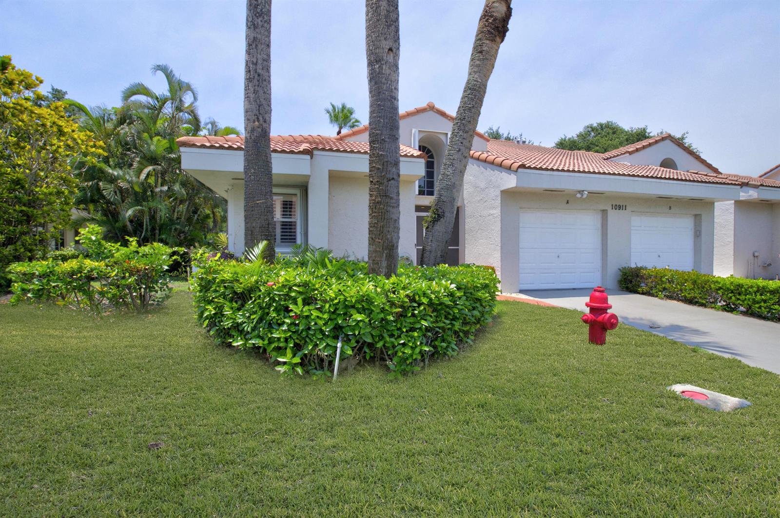 A single-story house with a tile roof, two garage doors, and a red fire hydrant — 10911 Ladera Lane # A, Boca Raton FL 33498, BOCA RATON, FL