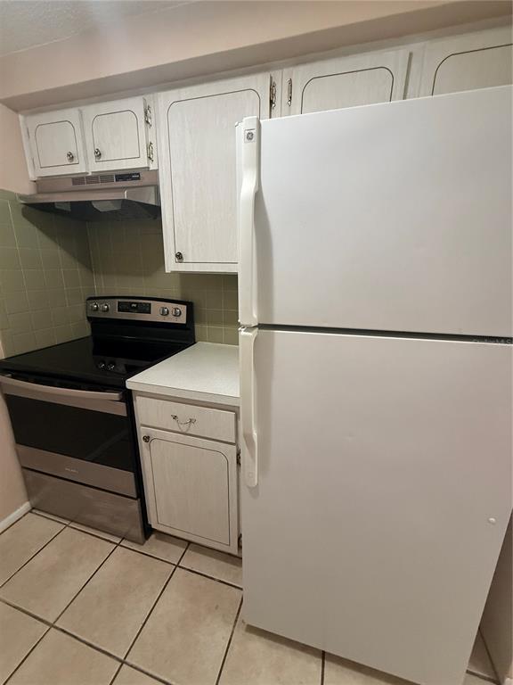 A kitchen features white cabinets, a stainless steel stove, and a white refrigerator — 4244 SHELDON PLACE UNIT 4244, NEW PORT RICHEY, FL