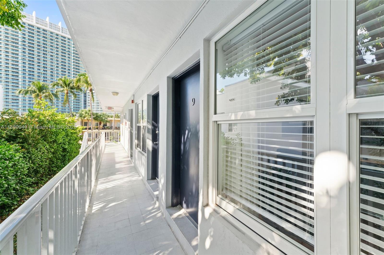 An outdoor walkway leads past a dark door marked with the number nine — 1515 WEST AVE # 9, Miami Beach FL 33139, MIAMI BEACH, FL