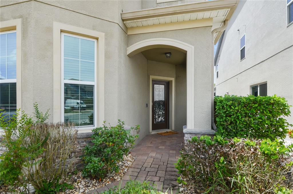 A paved walkway leads to the front entrance of a house with stucco siding — 5240 VILLA ROSA AVENUE, ST CLOUD, FL