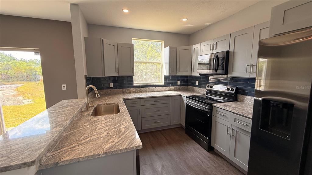 A two-story house with two garage doors and a concrete driveway under a blue sky — 6236 OLIVEDALE DRIVE, RIVERVIEW, FL