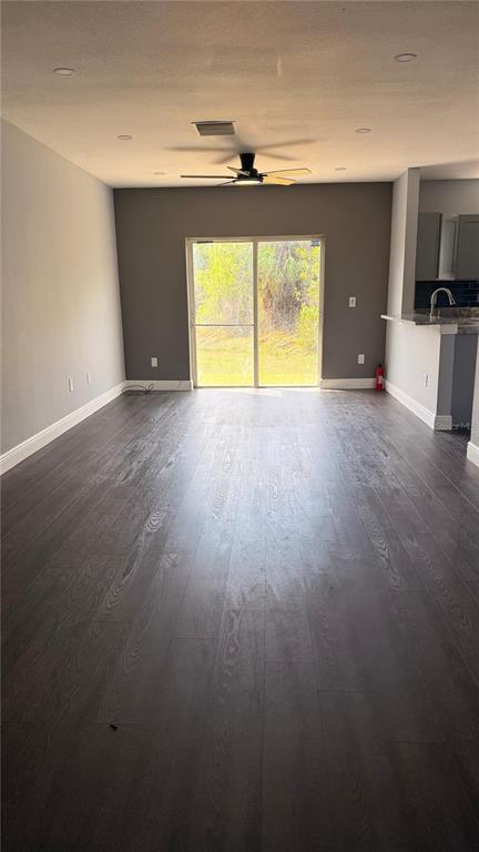 A kitchen features granite countertops, a stainless steel sink, and gray cabinets — 6236 OLIVEDALE DRIVE, RIVERVIEW, FL