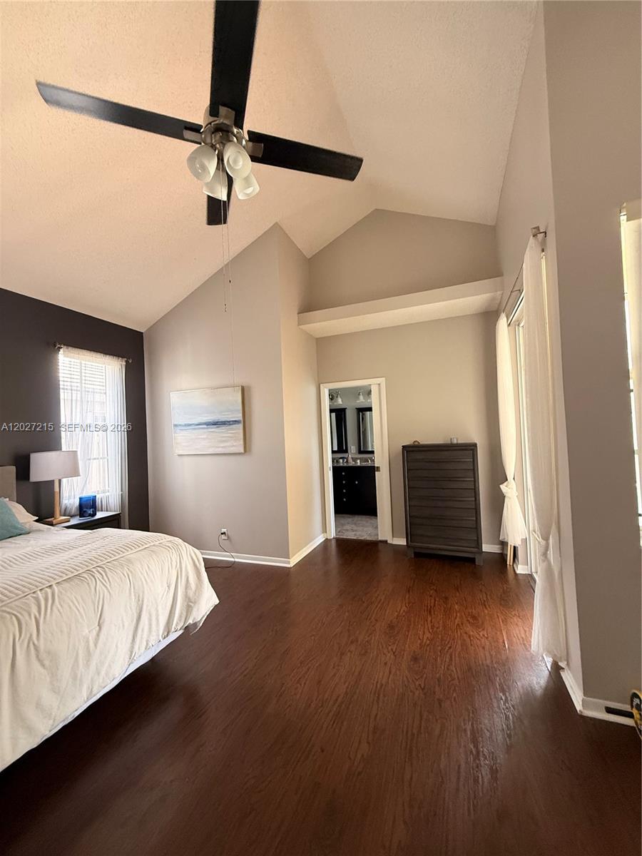 A bedroom with vaulted ceilings, dark wood flooring, and an attached bathroom — 300 Cameron Dr, Weston FL 33326, WESTON, FL
