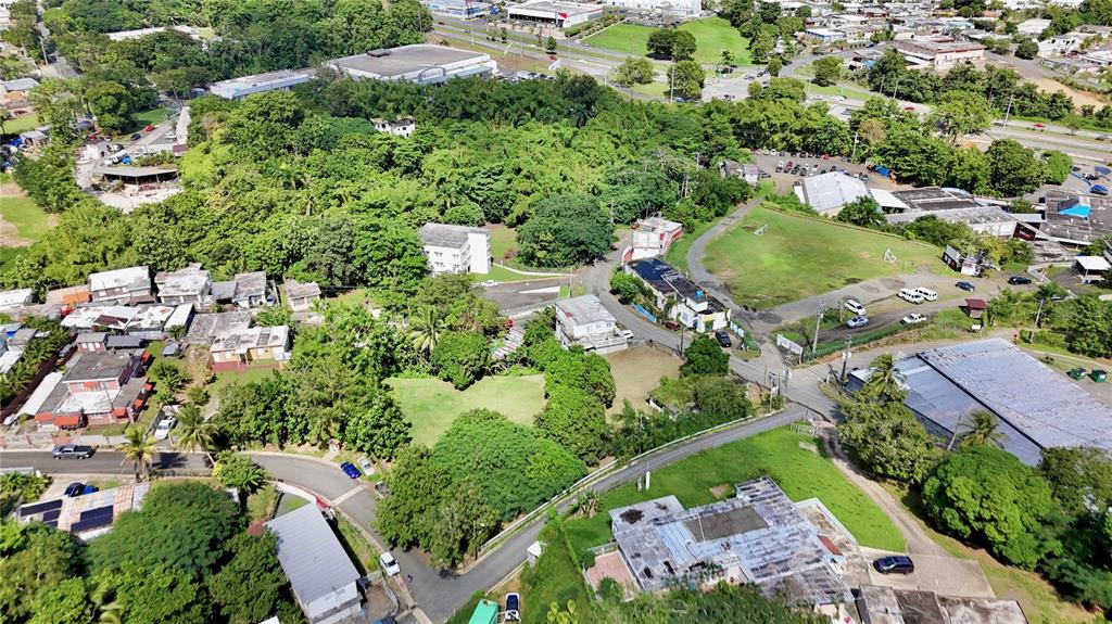 Aerial view of a residential neighborhood with houses, green spaces, and surrounding roads — PR-876 KM 0.7 BO LAS CUEVAS, TRUJILLO ALTO, PR