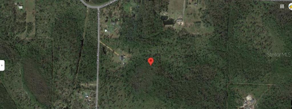 This is an aerial map view showing a red location pin on a wooded lot — N/A, FOUNTAIN, FL