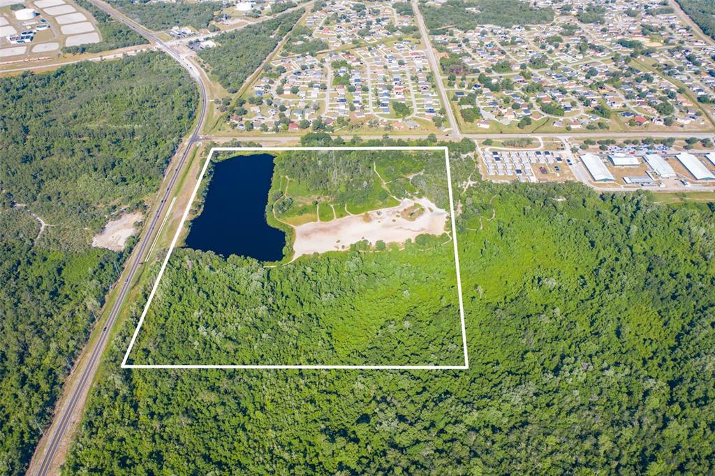 An aerial view shows a rectangular plot of land containing a lake and sandy area — LAUREL AVENUE, KISSIMMEE, FL