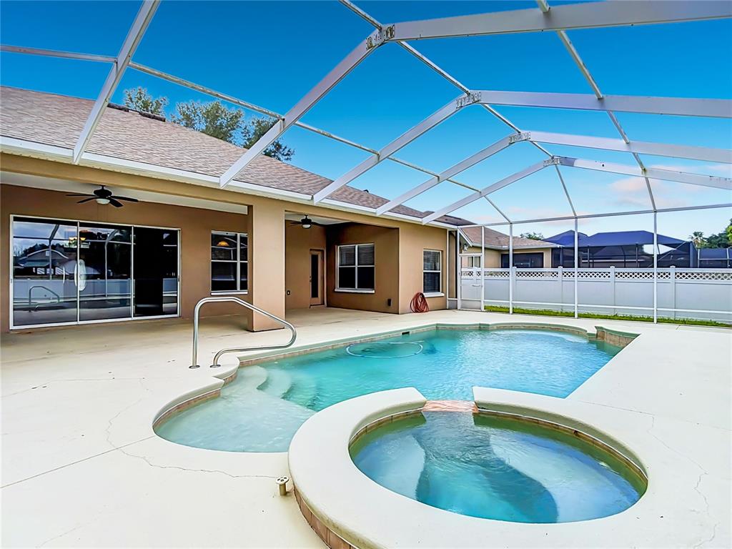 A screened-in patio features a swimming pool with an attached hot tub and concrete decking — 2866 DUNCAN TREE CIRCLE, VALRICO, FL