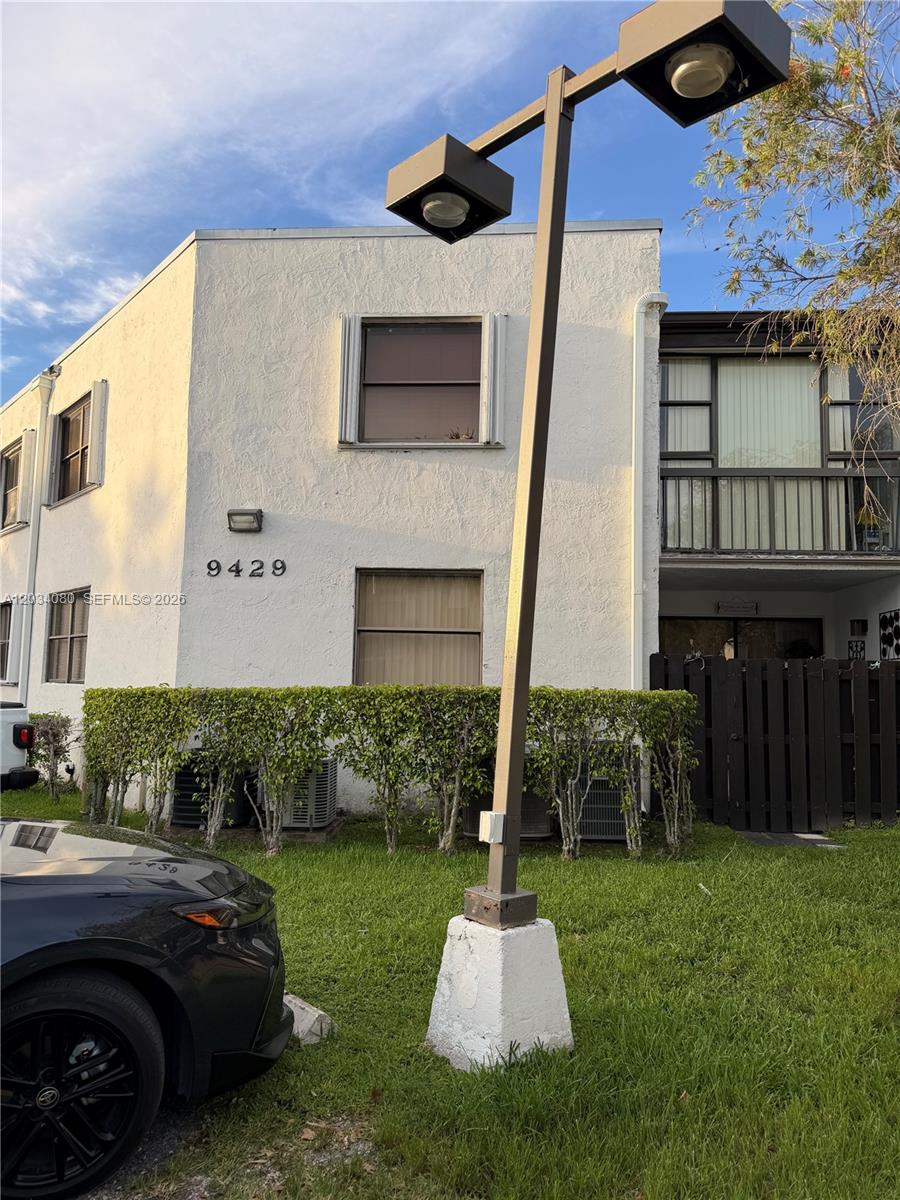 A two-story white stucco building features a street lamp in the foreground and landscaping — 9429 Fontainebleau Blvd # 33, Miami FL 33172, MIAMI, FL