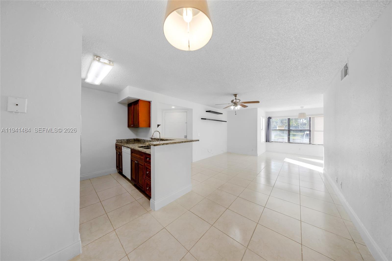 An open-concept living area features a kitchen with wood cabinets and tile flooring throughout — 2986 S University Dr # 8101, Davie FL 33328, DAVIE, FL