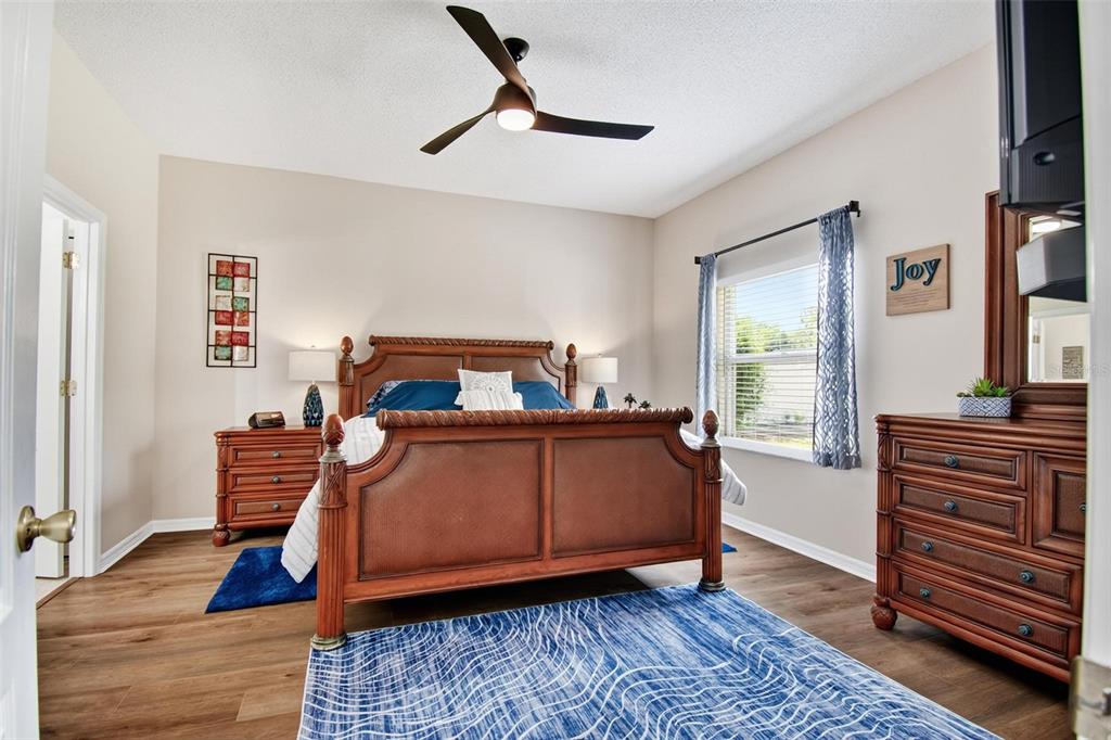 A bedroom features a wooden bed frame, a dresser, and a blue patterned area rug — 29 ETHAN ALLEN DRIVE, PALM COAST, FL