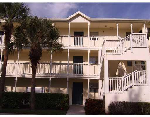 A three-story apartment building features exterior staircases, balconies, and palm trees in front — 6355 La Costa Drive # L, Boca Raton FL 33433, BOCA RATON, FL