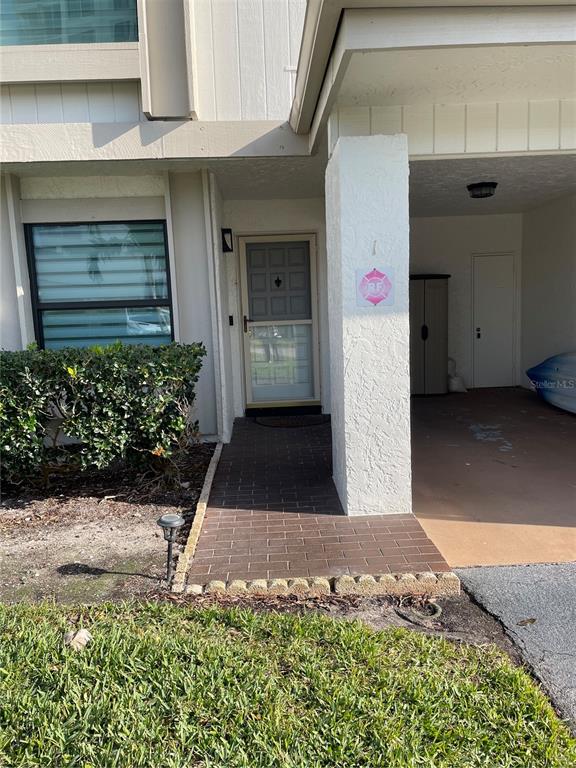A brick walkway leads to the front door of a home with a covered carport — 6260 SUN BOULEVARD UNIT 1, ST PETERSBURG, FL