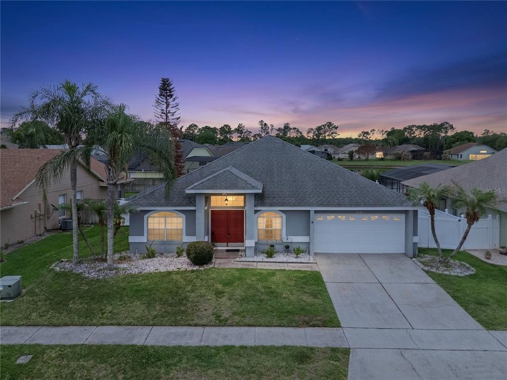 A single-story house with a gray exterior, red double front doors, and a two-car garage — 12422 MARLEIGH COURT, ORLANDO, FL