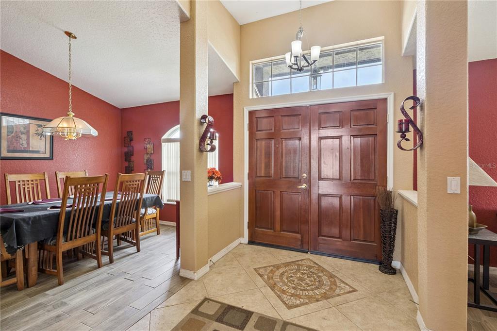 A foyer with tile flooring and a double wood door leads into a dining room — 12422 MARLEIGH COURT, ORLANDO, FL
