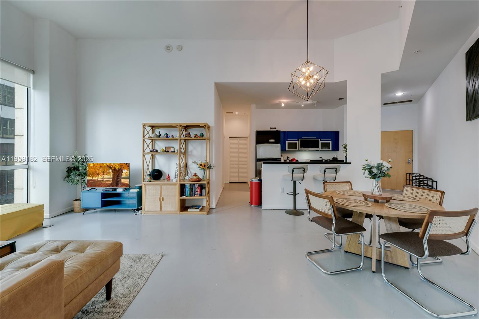 An open-concept living and dining area features a modern kitchen, light flooring, and high ceilings — 253 NE 2nd St # 228, Miami FL 33132, MIAMI, FL