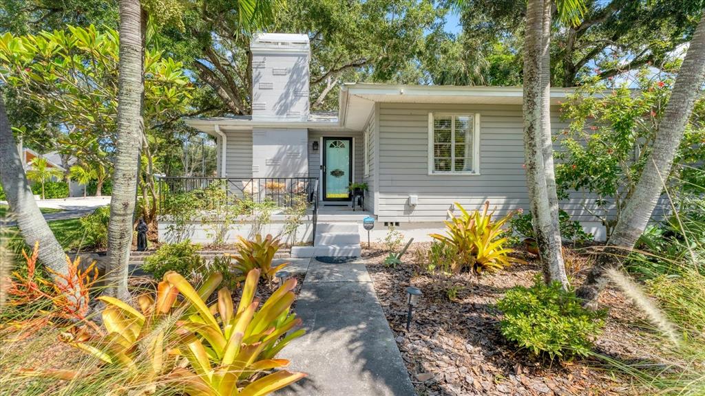 A gray house with a prominent chimney, a front porch, and a landscaped yard — 401 28TH STREET W, BRADENTON, FL