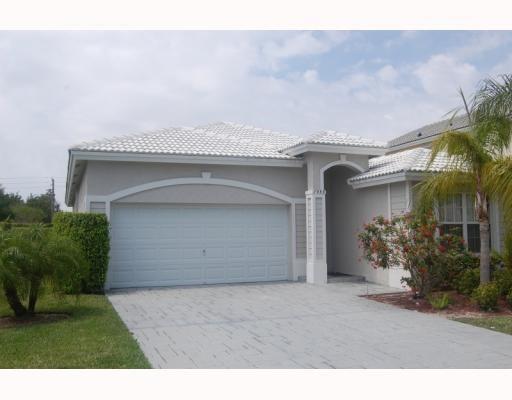 A single-story house with a white tiled roof, gray stucco exterior, and a two-car garage — 7953 NW 70th Avenue, Parkland FL 33067, PARKLAND, FL