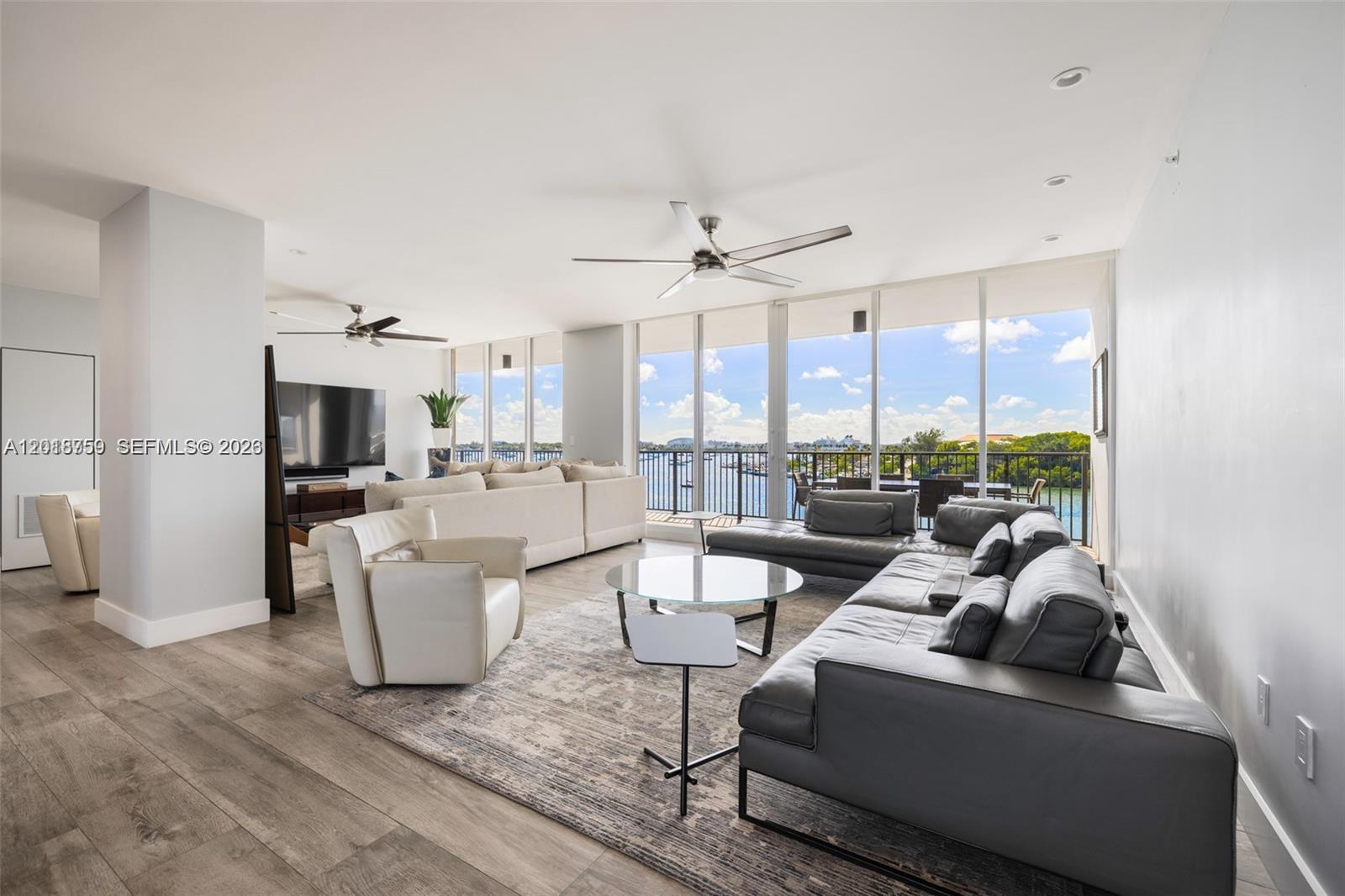 A spacious living room features two large sofas, a glass coffee table, and floor-to-ceiling windows — 1000 Venetian Way # 502, Miami FL 33139, MIAMI, FL