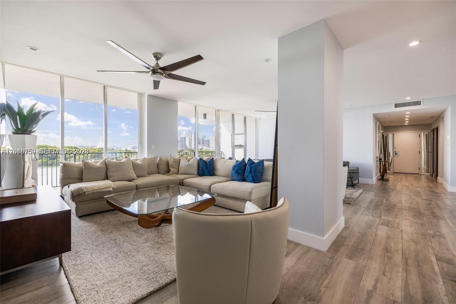 A living room features a large sectional sofa, glass coffee table, and floor-to-ceiling windows — 1000 Venetian Way # 502, Miami FL 33139, MIAMI, FL