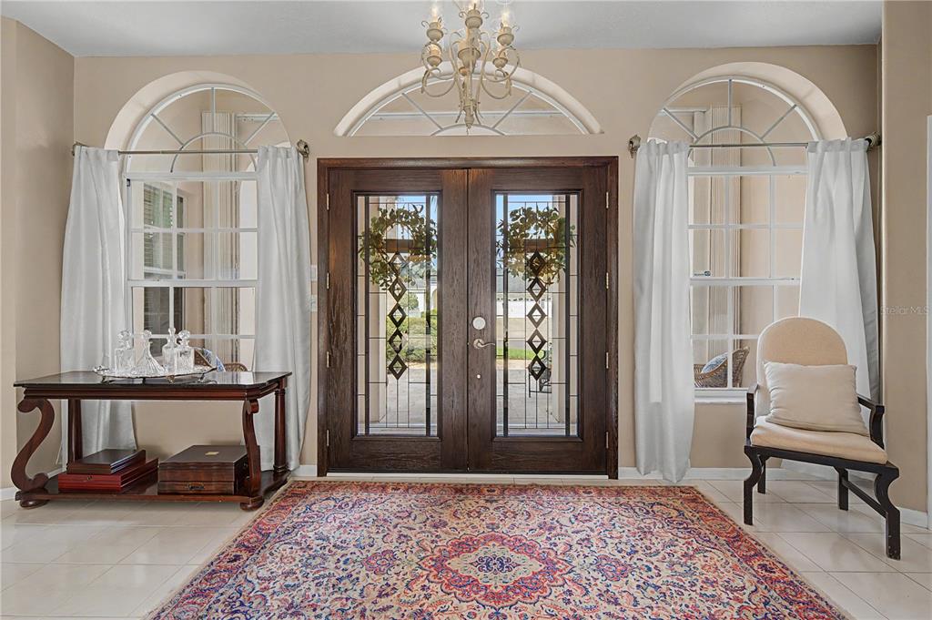 A single-story suburban house with a three-car garage, arched entryway, and a palm tree — 2093 SWAN LANE, PALM HARBOR, FL