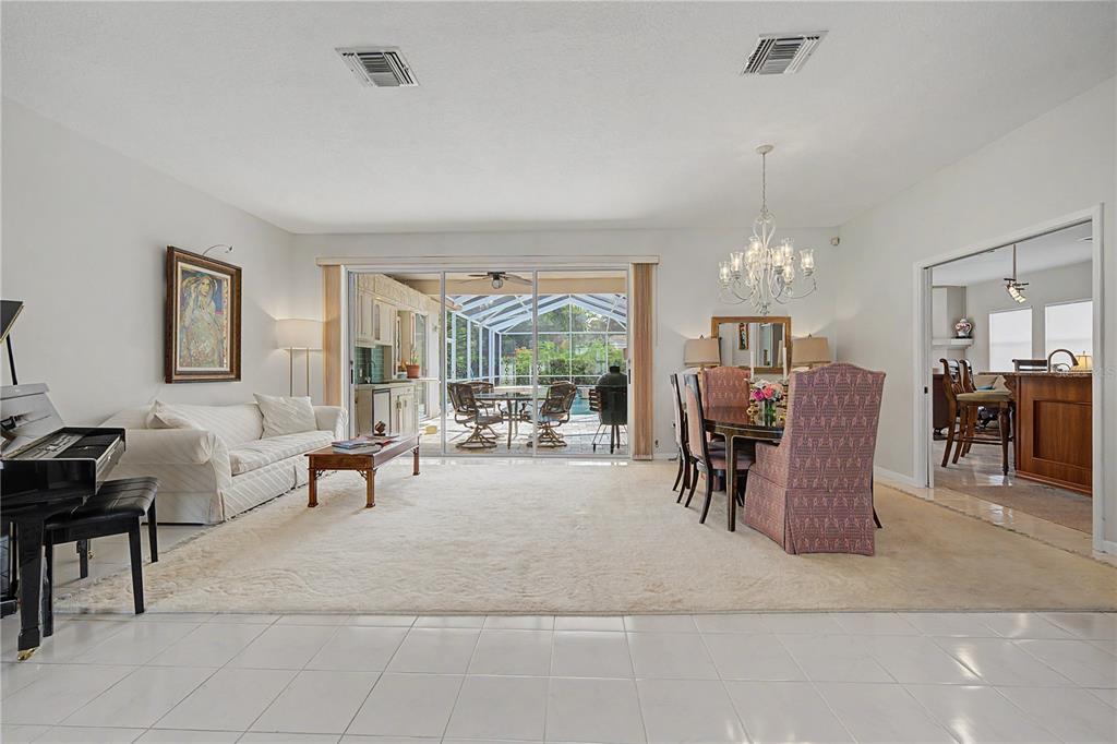 A screened-in pool area features a kidney-shaped pool, a raised spa, and stone paver decking — 2093 SWAN LANE, PALM HARBOR, FL
