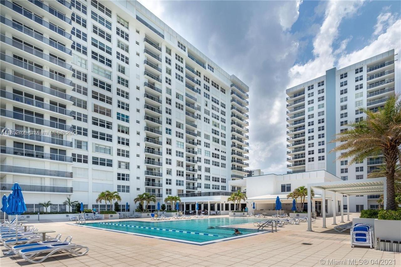 A swimming pool sits on a paved deck in front of two large apartment buildings — 2751 S Ocean Dr, Hollywood FL 33019, HOLLYWOOD, FL