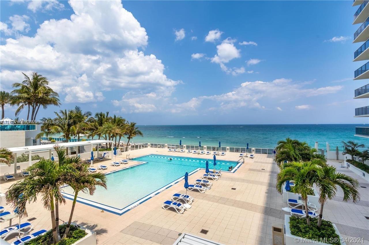 An outdoor swimming pool overlooks the ocean from a paved deck with palm trees — 2751 S Ocean Dr, Hollywood FL 33019, HOLLYWOOD, FL