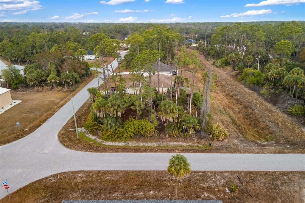An aerial view shows a wooded residential lot situated at a road intersection — DUMA WAY, NORTH PORT, FL