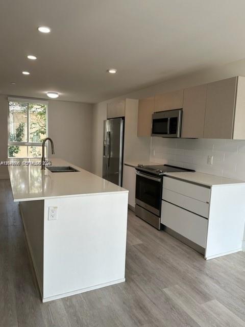 A modern kitchen features white cabinets, a large island with a sink, and stainless appliances — 2561 NE 193rd St # 1208, Miami FL 33180, MIAMI, FL