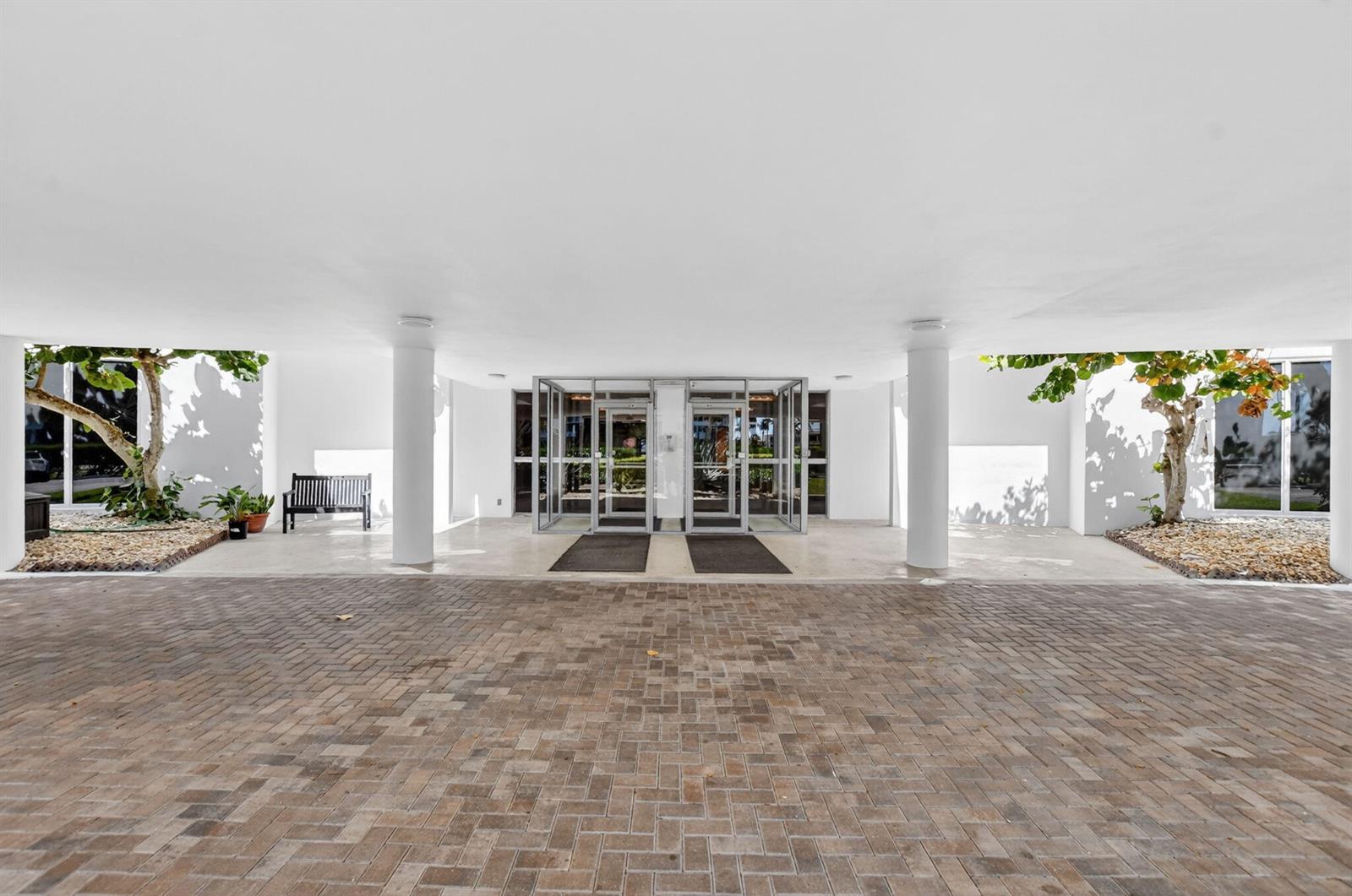 A paved driveway leads to the covered entrance of a building with glass double doors — 2851 S Ocean Boulevard # 2, Boca Raton FL 33432, BOCA RATON, FL