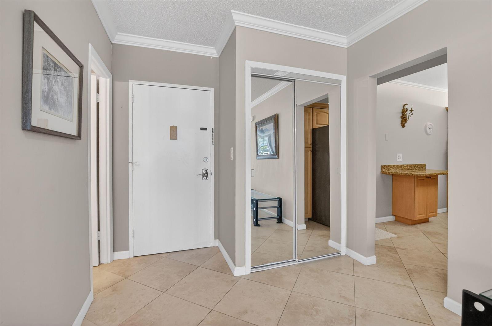 An entryway features a white door, mirrored closet doors, and beige tile flooring — 2851 S Ocean Boulevard # 2, Boca Raton FL 33432, BOCA RATON, FL