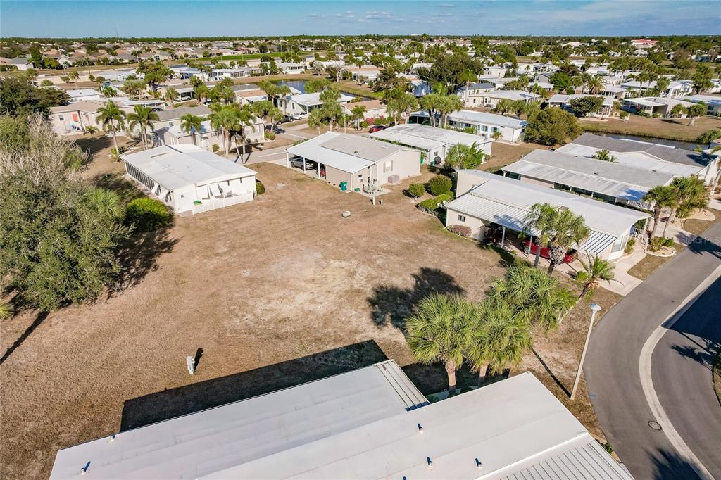 An aerial view shows a vacant lot situated between several manufactured homes in a residential community — 2100 KINGS HIGHWAY UNIT 1092, PORT CHARLOTTE, FL