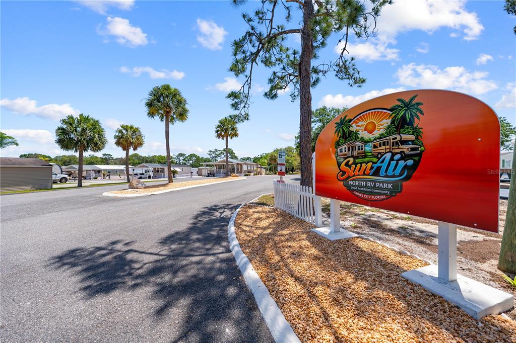 A sign for Sun Air North RV Park stands beside a paved road with palm trees — 34 FAIRVIEW DRIVE N, HAINES CITY, FL