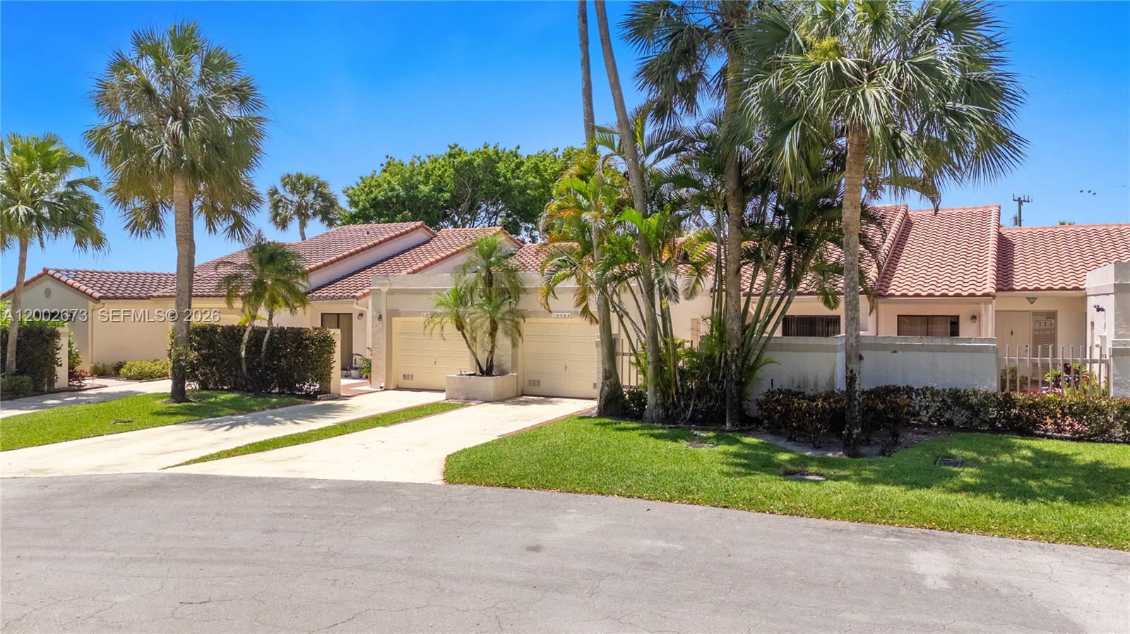 A single-story residential building features a tiled roof, two garage doors, and palm trees — 19988 Rima Cir, Boca Raton FL 33434, BOCA RATON, FL