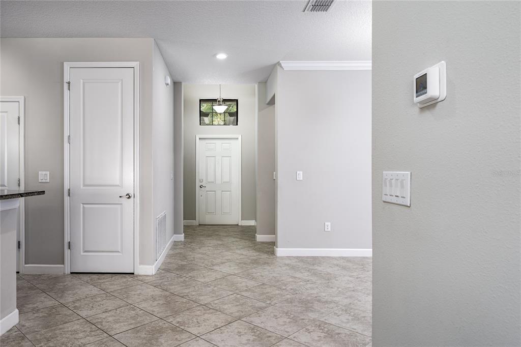 A tiled entryway leads to a white front door with a transom window above — 10009 CELTIC ASH DRIVE, RUSKIN, FL
