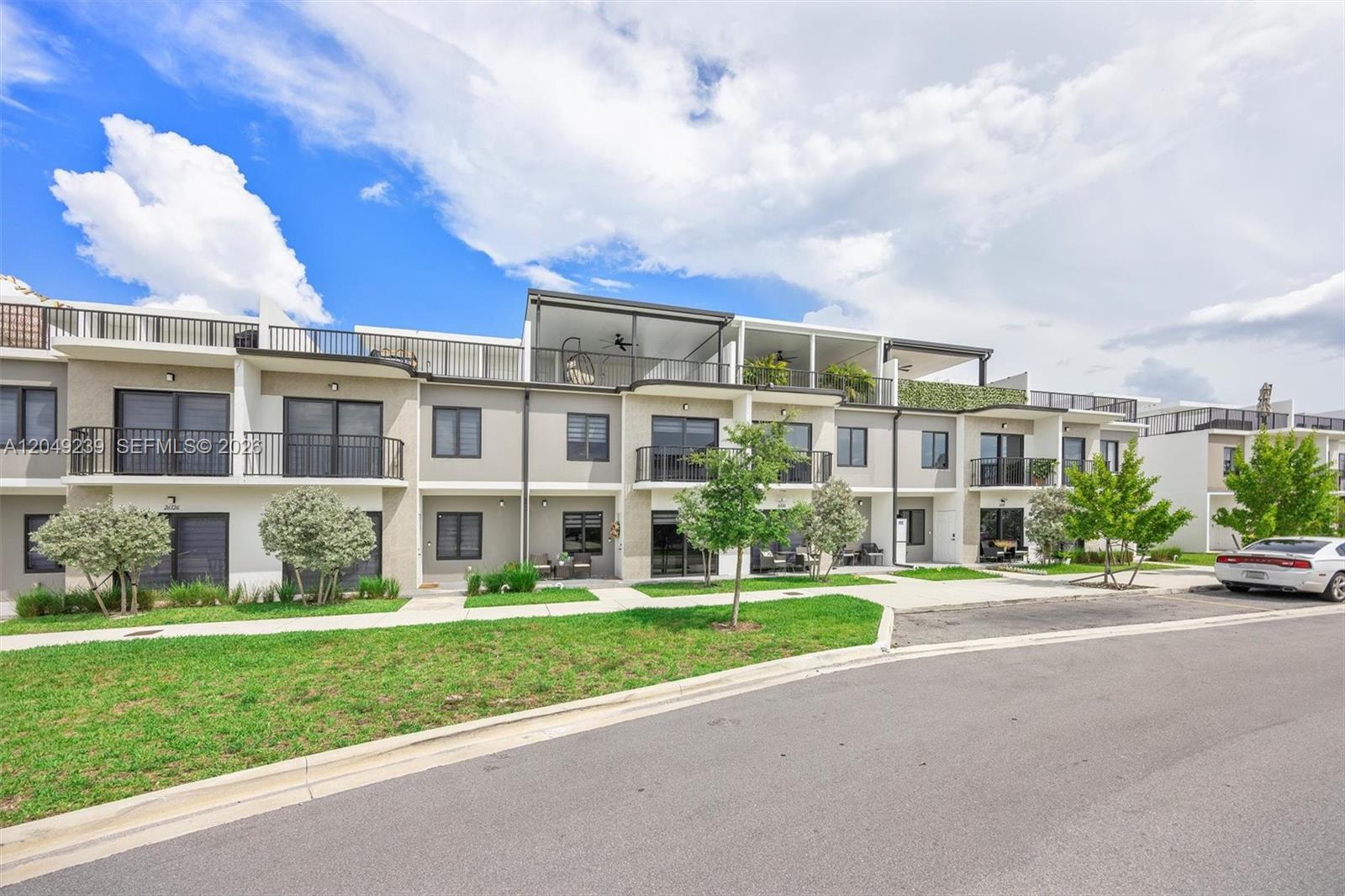 A row of modern two-story townhomes with balconies and a paved street in front — 26122 SW 146th Ave, Homestead FL 33032, HOMESTEAD, FL