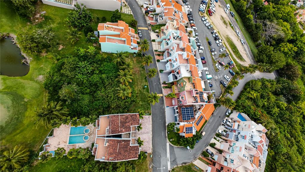 An aerial view shows a residential complex with terraced buildings, a swimming pool, and parking — MonteSol 11 PALMANOVA UNIT 150 - 151, HUMACAO, PR