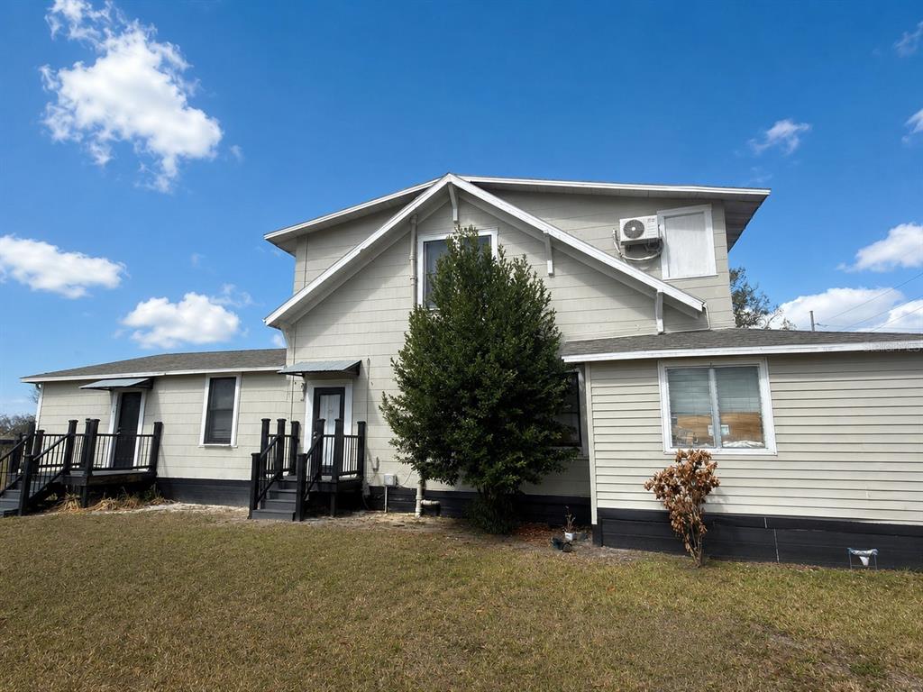 The exterior of a two-story house with light siding, black trim, and two small porches — 1339 7TH STREET SW, WINTER HAVEN, FL