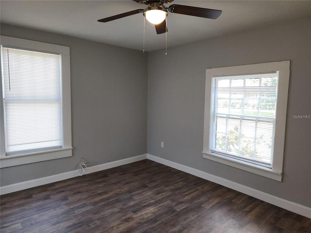 A bedroom with gray walls, wood-look flooring, two windows, and a ceiling fan — 1339 7TH STREET SW, WINTER HAVEN, FL