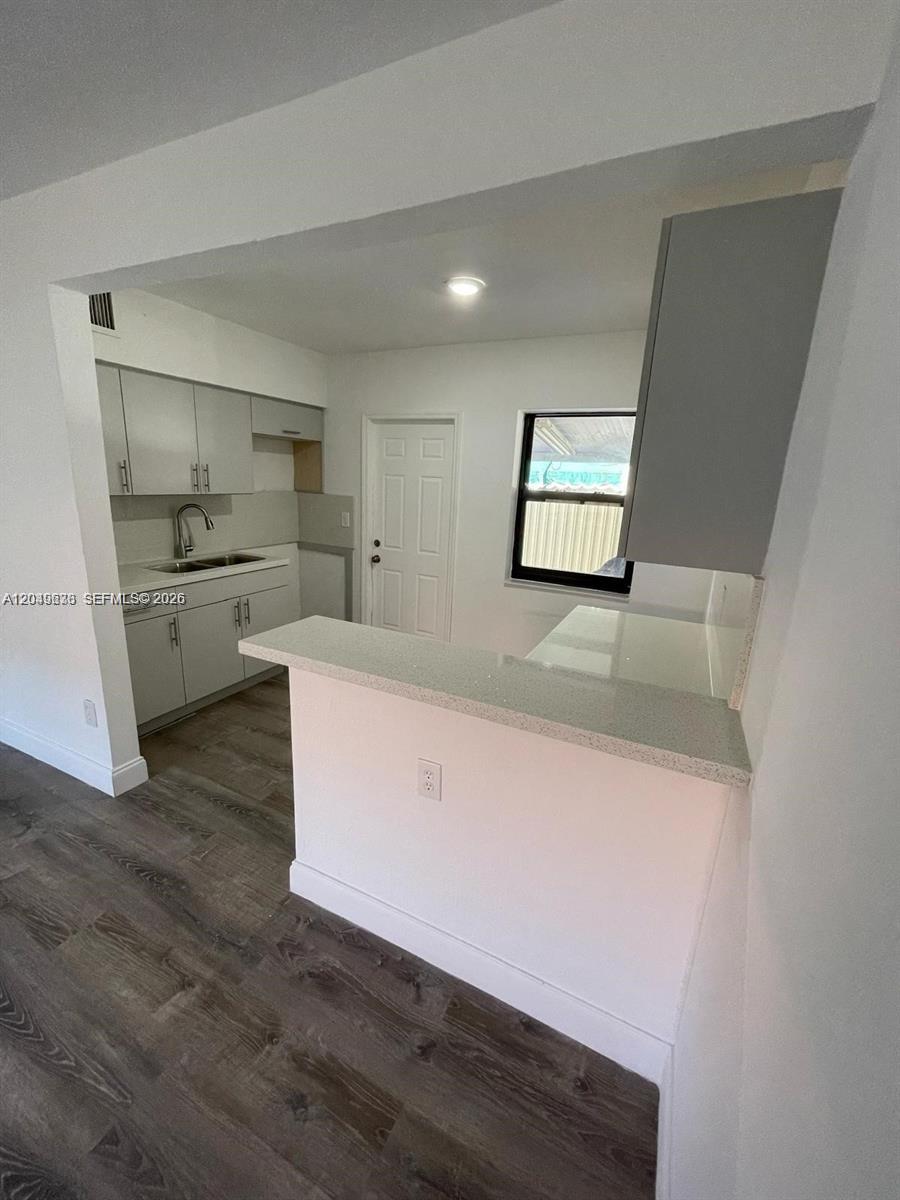 A kitchen features light gray cabinets, white countertops, and wood-look flooring — 7360 SW 21st St # 7360, Miami FL 33155, MIAMI, FL