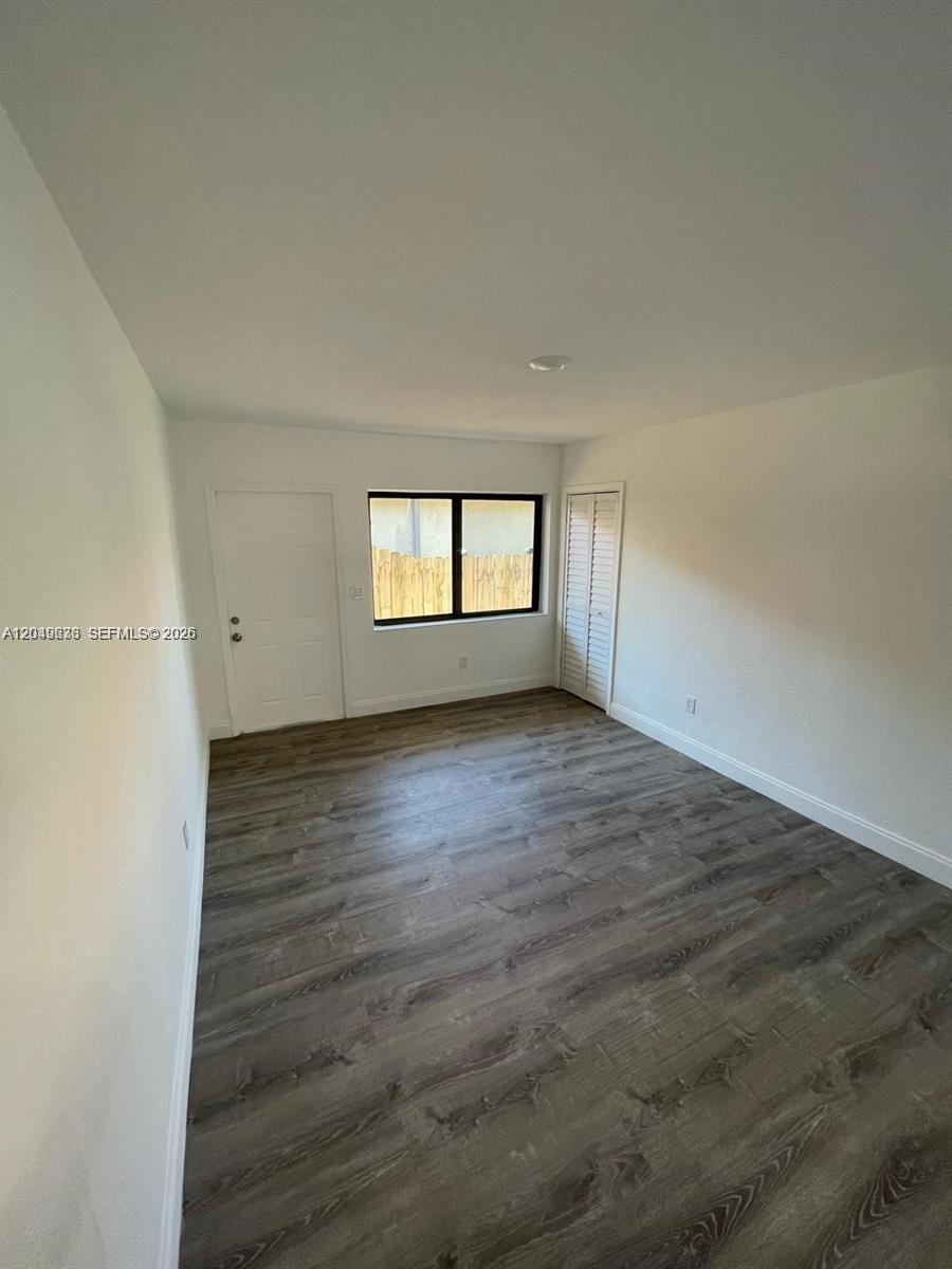 An empty bedroom features white walls, a single window, and wood-look laminate flooring — 7360 SW 21st St # 7360, Miami FL 33155, MIAMI, FL