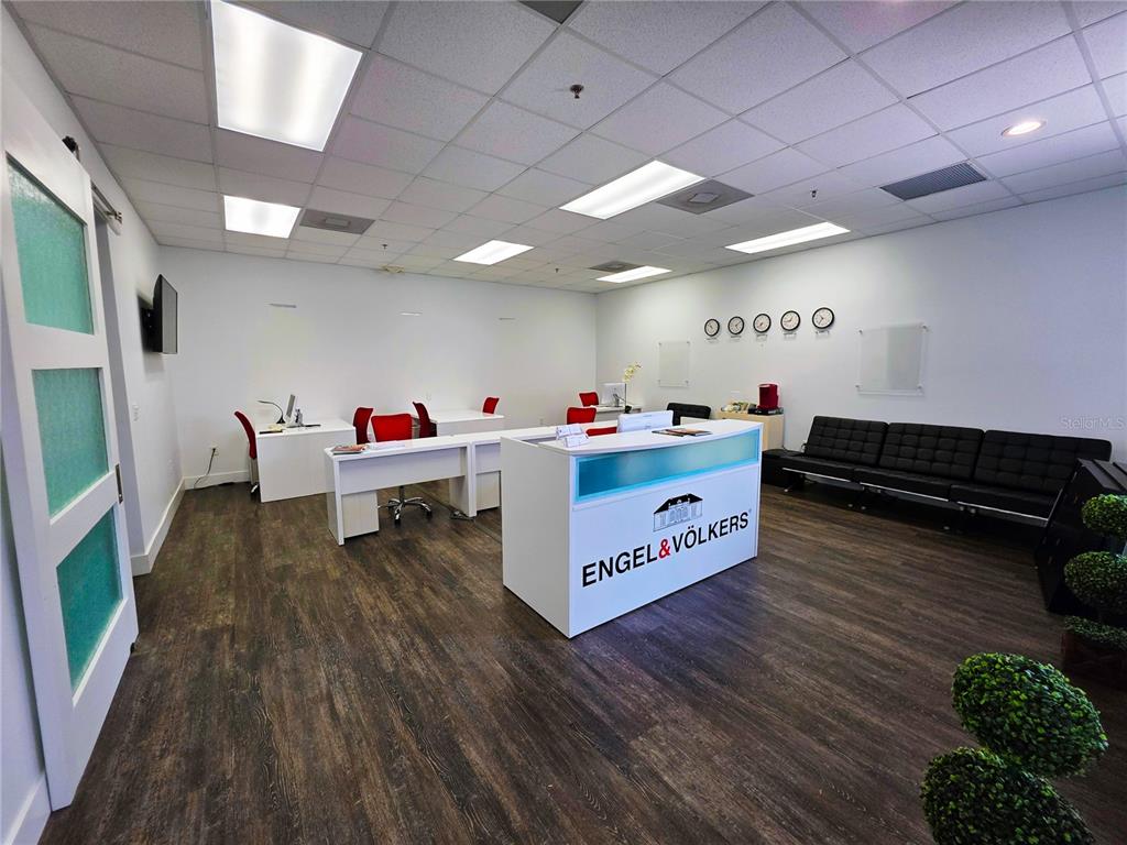A modern office space features a reception desk, white workstations, and a black seating area — 7600 DR. PHILLIPS BOULEVARD UNIT 53, ORLANDO, FL
