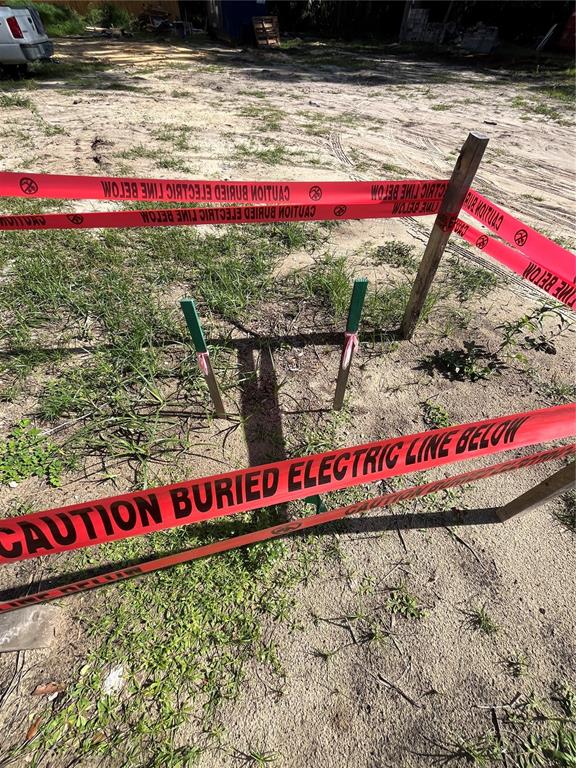 A construction site features caution tape marking a buried electric line near two green stakes — 262 NW 12TH AVENUE, GAINESVILLE, FL