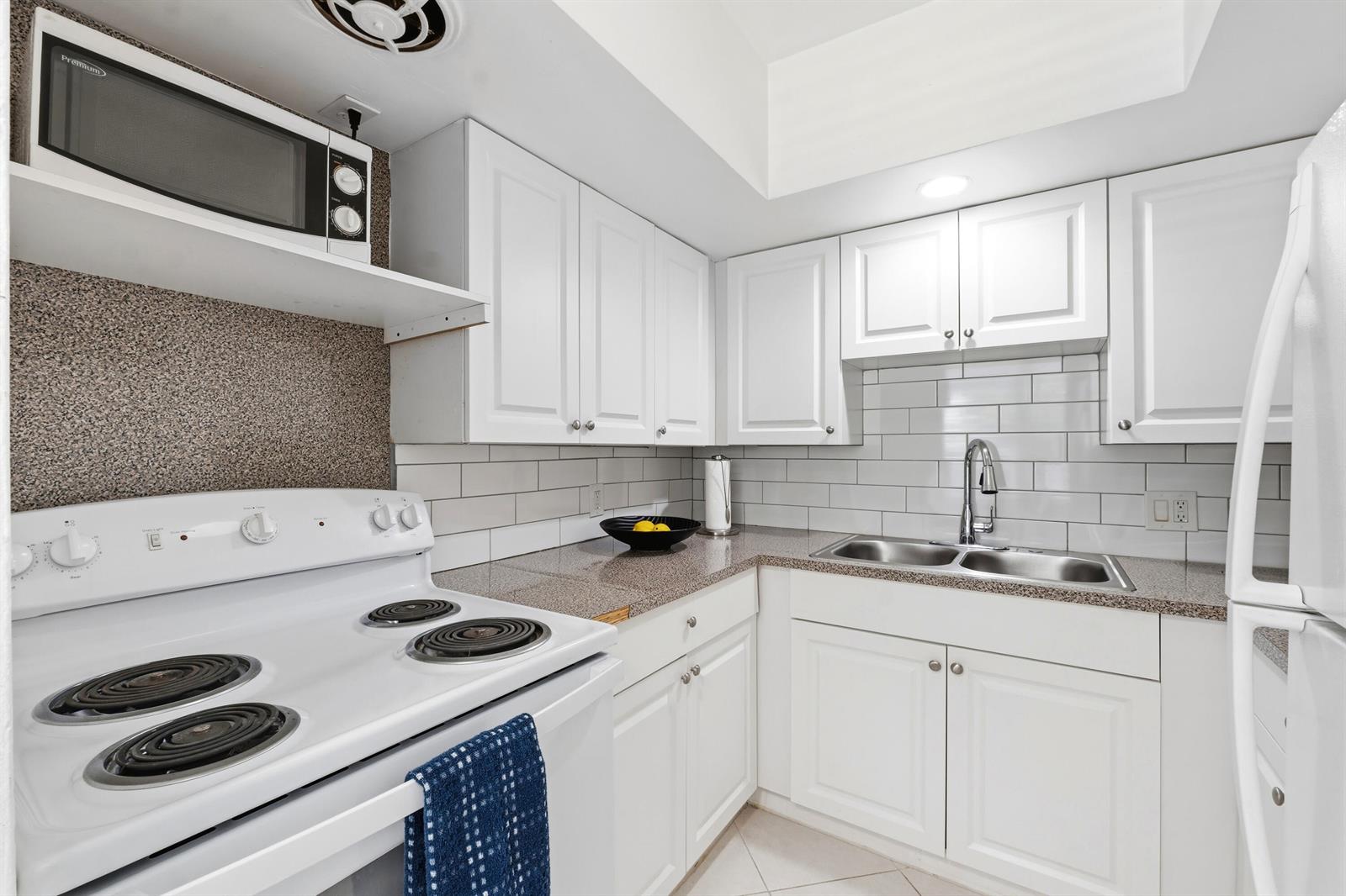 A kitchen with white cabinets, a white electric stove, and a granite countertop — 23 NE 19th Avenue, Pompano Beach FL 33060, POMPANO BEACH, FL