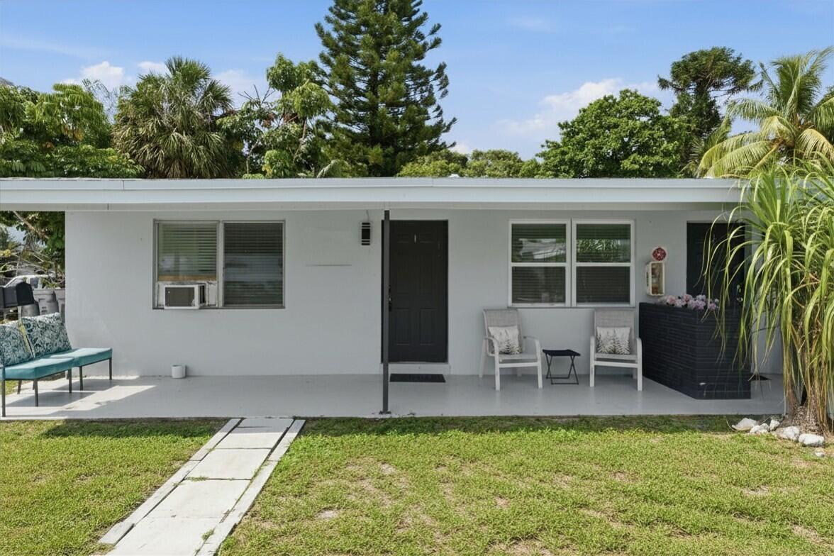 A single-story white house with a covered front porch, lawn, and palm tree — 23 NE 19th Avenue, Pompano Beach FL 33060, POMPANO BEACH, FL