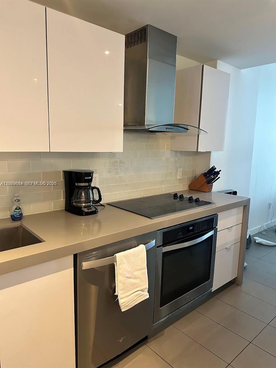 A modern kitchen features white cabinets, stainless steel appliances, and a gray countertop — 1600 NE 1st Ave # 1612, Miami FL 33132, MIAMI, FL