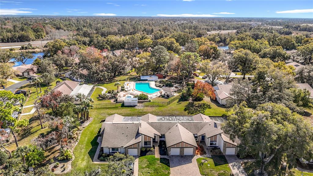 An aerial view shows a multi-unit residential building with a swimming pool in the background — 7385 CRESTWOOD DRIVE, WEEKI WACHEE, FL