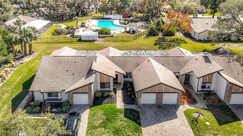 An aerial view shows a multi-unit residential building with a pool area in the background — 7385 CRESTWOOD DRIVE, WEEKI WACHEE, FL